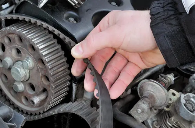 Mecânico substituindo correia dentada no motor em oficina de Jacareí